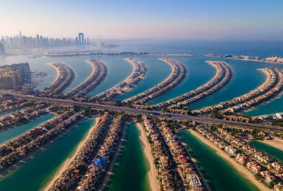 The Palm Jumeirah shaped island in Dubai United Arab Emirates aerial view at sunrise. Famous man made palm shaped island with luxury waterfront villas and hotels surrounded by seaside